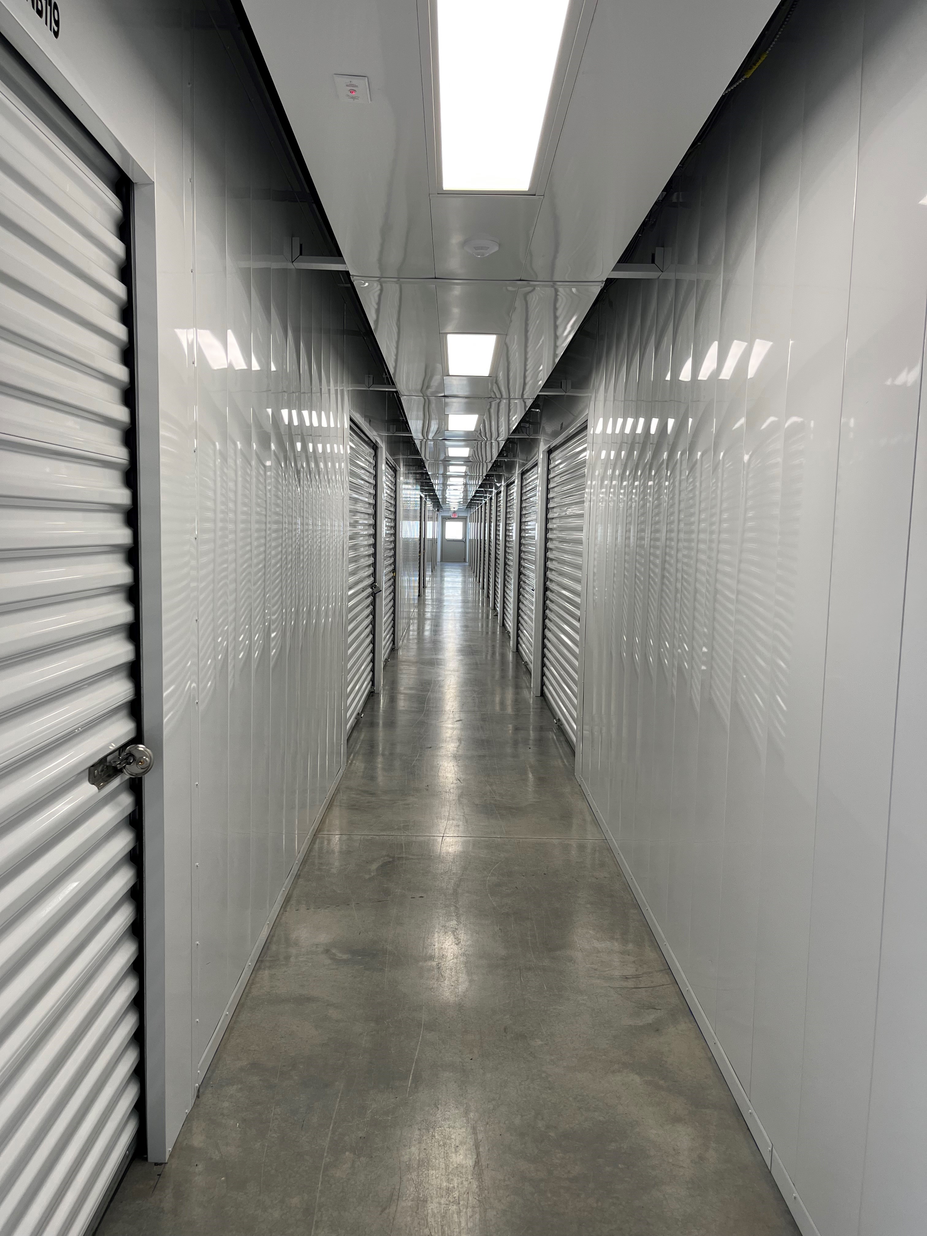 Climate-controlled storage interior at Huntingburg Access Storage, featuring pristine white doors and a spotless hallway for a secure, clean environment.
